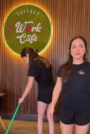 Una barista del equipo frente al letrero